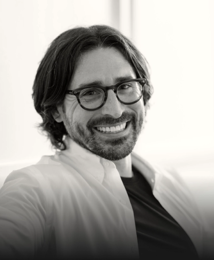 Black-and-white portrait of a smiling man with glasses
